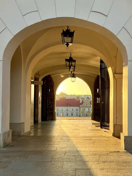 Günbatımında Lublin Kalesi 'nin kapıları, Polonya. Gün batımında demir kapılı taş kemer yolu. Sıcak, altın ışık iç mekanı aydınlatıyor, döşeme üzerinde uzun gölgeler bırakıyor.. 