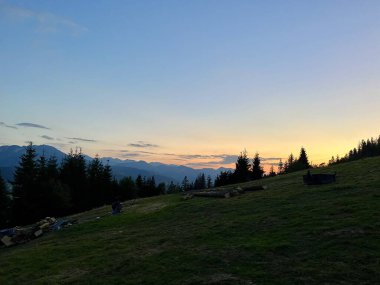 Tatra dağlarında gün batımı, Zakopane, Polonya. Karanlık, sivri dağ siluetleri yumuşak portakallar ve mavilerden oluşan solgun bir gökyüzüne karşı yükseliyor.. 