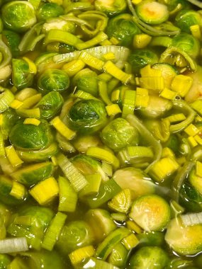 Sebzeler pişiyor. Sağlıklı beslenme, vegan tarifler. Brüksel lahanası ve pırasa dilimleri sıvı et suyunda kaynayarak sebze güveci oluşturur.. 