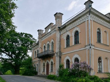 Büyük tarihi Glitiskes malikanesi bej, sıva dış görünüşlü, kemerli pencereler ve dekoratif pervazlarla süslenmiş. İkinci katta dövülmüş demir bir balkon olduğu sanılıyor. Litvanya 