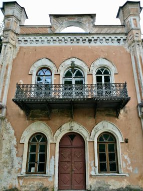 Büyük tarihi Glitiskes malikanesi bej, sıva dış görünüşlü, kemerli pencereler ve dekoratif pervazlarla süslenmiş. İkinci katta dövülmüş demir bir balkon olduğu sanılıyor. Litvanya 