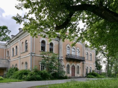 Büyük tarihi Glitiskes malikanesi bej, sıva dış görünüşlü, kemerli pencereler ve dekoratif pervazlarla süslenmiş. İkinci katta dövülmüş demir bir balkon olduğu sanılıyor. Litvanya 
