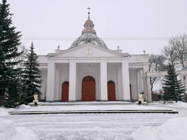 Daugavpils 'deki Aziz Peter-in-Chains Katolik Kilisesi belirgin beyaz cephesi ve merkezi kubbesi olan Neoklasik Kilisesi. Girişi destekleyen dört büyük kolon var. Kar zemini kaplıyor. 