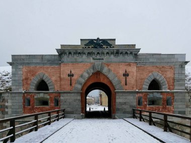 Daugavpils Kalesi 'ndeki Nicholas Gate kırmızı tuğlalar ve gri taştan yapılmış. Dekoratif siyah demir parçaları ve iki başlı bir kartalın rahatlaması ön cepheyi süslüyor.. 