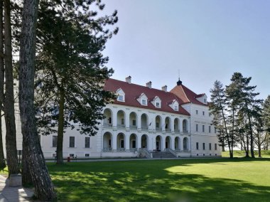 Litvanya 'daki Birzai Kalesi. Kırmızı kiremitli çatısı ve birden fazla yurt penceresi olan büyük, beyaz, iki katlı bir bina.. 