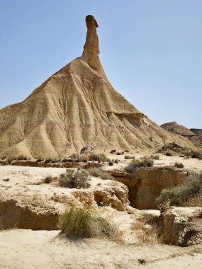 Navarre, İspanya 'daki yarı çöl Bardenas Reales' in panoramik manzarası. Keskin bir şekilde yükselen kumtaşı mihenk taşı. Arazi, yarı kurak bir çevreyi yansıtan dağınık çalılarla verimsizdir.. 