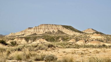 Bardenas Reales 'in Navarre, İspanya' daki yarı çöl manzarasının panoramik görüntüsü. Görüntü aşınmış, katmanlı tepeler, engebeli dokular ve kahverengi ve bej renklerin değişik tonlarında..