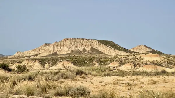 Bardenas Reales 'in Navarre, İspanya' daki yarı çöl manzarasının panoramik görüntüsü. Görüntü aşınmış, katmanlı tepeler, engebeli dokular ve kahverengi ve bej renklerin değişik tonlarında..