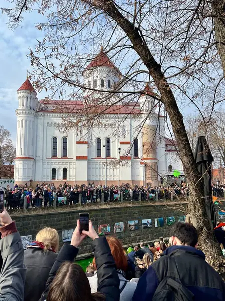 Vilnius 'ta Aziz Patrik Günü kutlaması. Parlak yeşil bir nehrin kıyısında bir kalabalık toplanır.. 