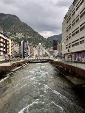 Andorra la Vella, Andorra 'nın tarihi merkezinde nehir. Nehir Andorra la Vella 'daki hareketli bir şehir merkezinden akar. Kablolarla çarpıcı beyaz asma köprü suyu gerer.. 