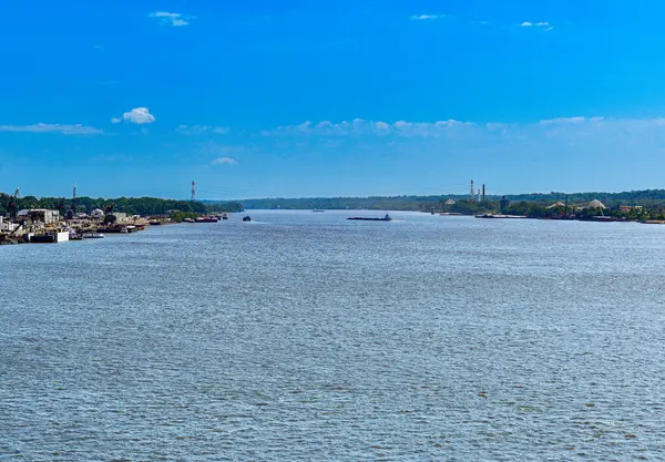 Kıyı şeridinde binaları ve mavnası olan büyük bir nehir.