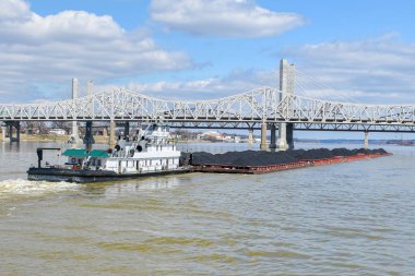 Nehirde kömür yüklü mavnaları iten römorkör.