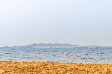 Katar 'daki Al-Adaid Çölü' nde iç deniz. Arka planda kireçtaşı tepeleri var.