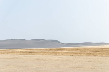 Katar 'da kum tepeleri olan çorak çöl manzarası