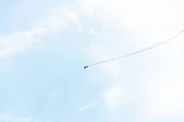 stock image A single aircraft performing aerobatics leaving smoke trail behind