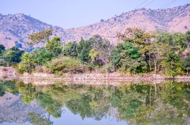 Udaipur 'dan Kumbalgarh Kalesi, Rajasthan, Hindistan' a giden kayalık arazide kıvrılan tatlı su nehirinin manzarası.