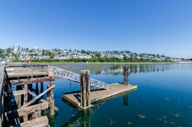 White Rock Pier ve Surrey, BC, Kanada 'daki Semiahmoo körfezi iç suları. Tepedeki Beyaz Kaya Kasabası evleri arka planda görünüyor.