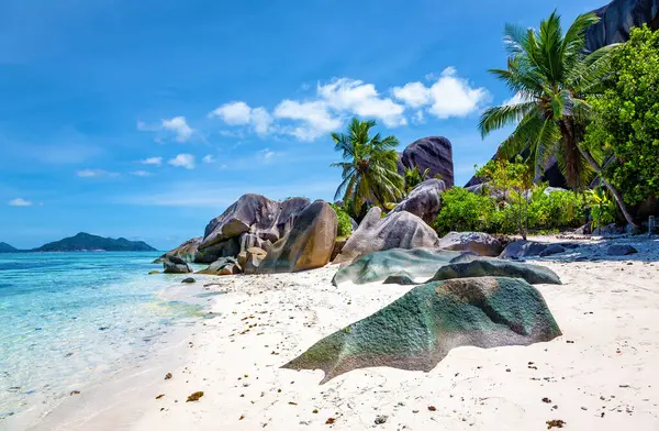 Source d 'Argent Sahili' ndeki kayalıklar, La Digue Adası. Arkaplanda Praslin Adası.