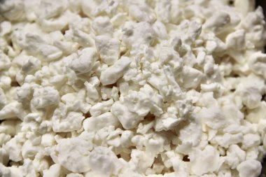 Taze beyaz süzme peynirin kumlu desenli makro fotoğrafçılığı. Yakın planda gösterilen yüksek kaliteli süt ürünü. Sağlıklı beslenme, süt ürünleri, mutfak malzemeleri veya