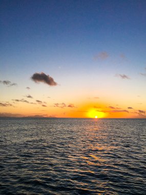Ufukta gün batımında WhitSunday Adası 'nda yelkenli bir teknede 
