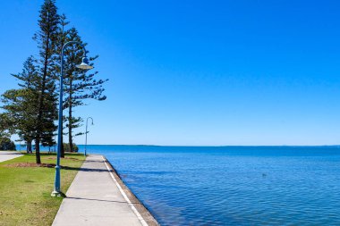 Wynnum İskelesi ve Manly 'deki sahil boyunca yürüyoruz. Güneşli, açık ve mavi bir gökyüzü. 