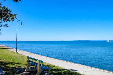 Wynnum İskelesi ve Manly 'deki sahil boyunca yürüyoruz. Güneşli, açık ve mavi bir gökyüzü. 