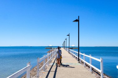 Wynnum İskelesi ve Manly 'deki sahil boyunca yürüyoruz. Güneşli, açık ve mavi bir gökyüzü. 