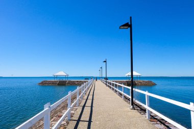 Wynnum İskelesi ve Manly 'deki sahil boyunca yürüyoruz. Güneşli, açık ve mavi bir gökyüzü. 