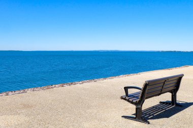 Güneşli güzel bir gün, berrak ve mavi bir gökyüzü, güneş ışığı ve martılar Wynnum iskelesinde, Manly, Brisbane CBD 'nin banliyölerinde uçuyor. 