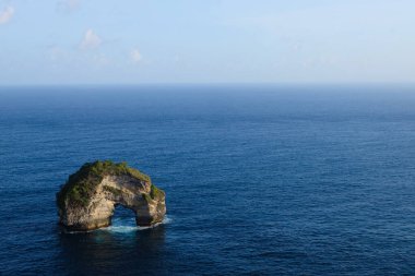 Okyanusu ve kaya oluşumunu Nusa Penida Adası, Bali, Endonezya 'daki Banah uçurumunda bir çörek ve dondurma külahı olarak görebilirsiniz.