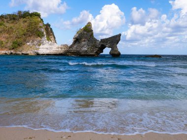 Okyanusu ve kaya oluşumunu Nusa Penida Adası, Bali, Endonezya 'daki Banah uçurumunda bir çörek ve dondurma külahı olarak görebilirsiniz.