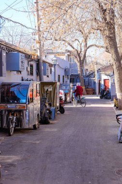 Pekin 'deki eski ara sokaklar, bisiklet, bisiklet ve elektrik tuktuk. 