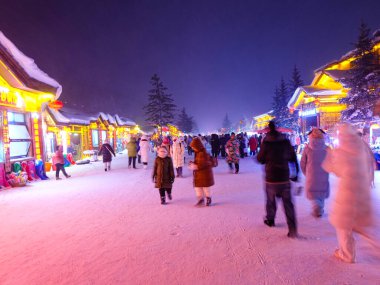 Geceleri Çin 'in karlı kasabasında renkli ışıklar var. 
