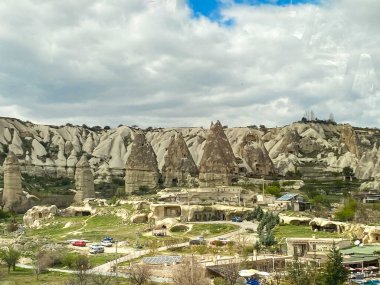 Goreme kasabasının, binaların, otellerin ve evlerin hava ve manzara manzarası peri bacaları ve mağara evlerinin doğal kaya oluşumlarıyla çevrili. 