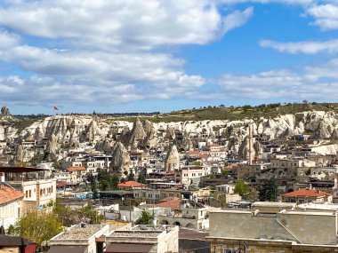 Goreme kasabasının, binaların, otellerin ve evlerin hava ve manzara manzarası peri bacaları ve mağara evlerinin doğal kaya oluşumlarıyla çevrili. 