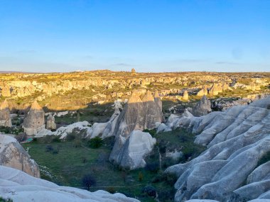 Goreme, Cappadocia 'da güzel bir günbatımında peri bacaları ve kırmızı vadi manzarası 