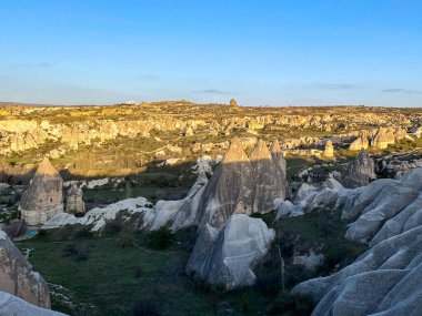 Goreme, Cappadocia 'da güzel bir günbatımında peri bacaları ve kırmızı vadi manzarası 