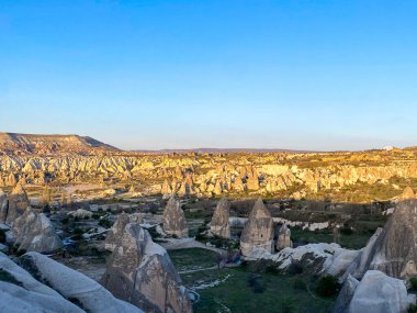 Goreme, Cappadocia 'da güzel bir günbatımında peri bacaları ve kırmızı vadi manzarası 
