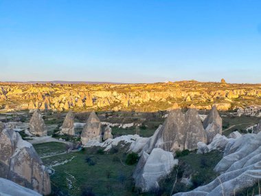 Goreme, Cappadocia 'da güzel bir günbatımında peri bacaları ve kırmızı vadi manzarası 