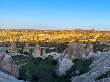 Goreme, Cappadocia 'da güzel bir günbatımında peri bacaları ve kırmızı vadi manzarası 