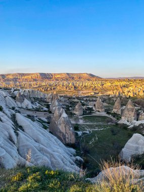Goreme, Cappadocia 'da güzel bir günbatımında peri bacaları ve kırmızı vadi manzarası 