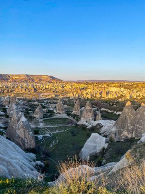 Goreme, Cappadocia 'da güzel bir günbatımında peri bacaları ve kırmızı vadi manzarası 
