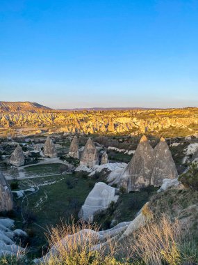 Goreme, Cappadocia 'da güzel bir günbatımında peri bacaları ve kırmızı vadi manzarası 