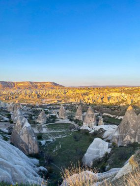 Goreme, Cappadocia 'da güzel bir günbatımında peri bacaları ve kırmızı vadi manzarası 