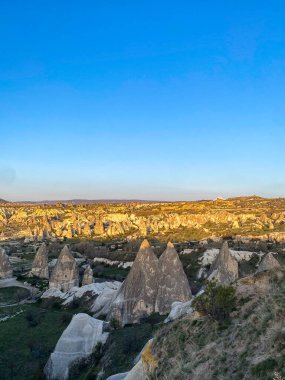 Goreme, Cappadocia 'da güzel bir günbatımında peri bacaları ve kırmızı vadi manzarası 
