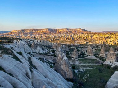 Goreme, Cappadocia 'da güzel bir günbatımında peri bacaları ve kırmızı vadi manzarası 
