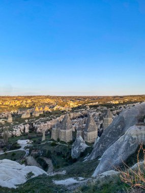 Goreme, Cappadocia 'da güzel bir günbatımında peri bacaları ve kırmızı vadi manzarası 