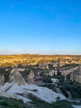 Goreme, Cappadocia 'da güzel bir günbatımında peri bacaları ve kırmızı vadi manzarası 