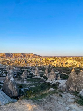 Goreme, Cappadocia 'da güzel bir günbatımında peri bacaları ve kırmızı vadi manzarası 
