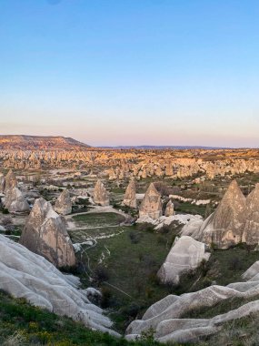 Goreme, Cappadocia 'da güzel bir günbatımında peri bacaları ve kırmızı vadi manzarası 